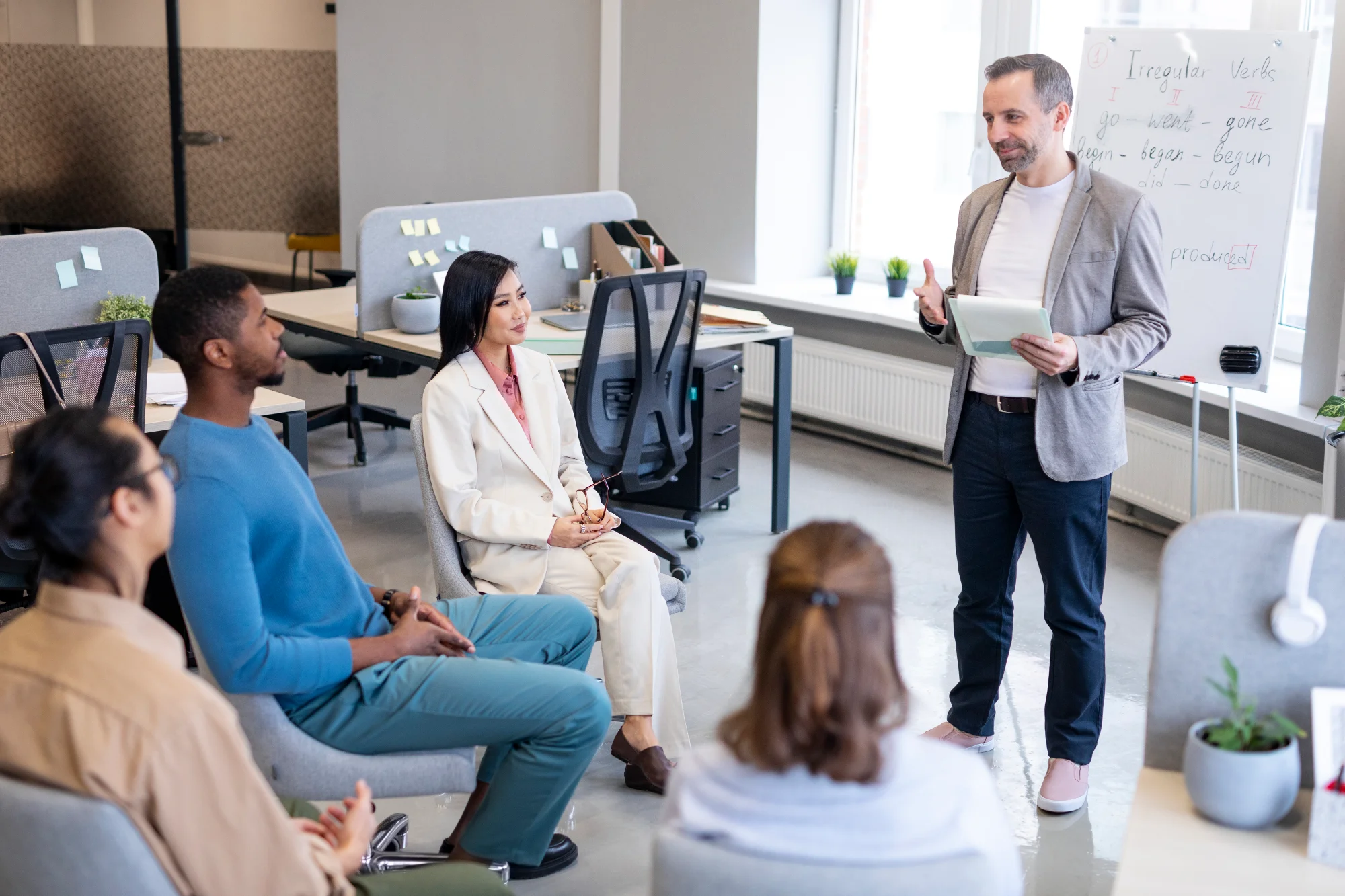 Grupo de empleados en una sesión de formación presencial en la sala de una universidad corporativa